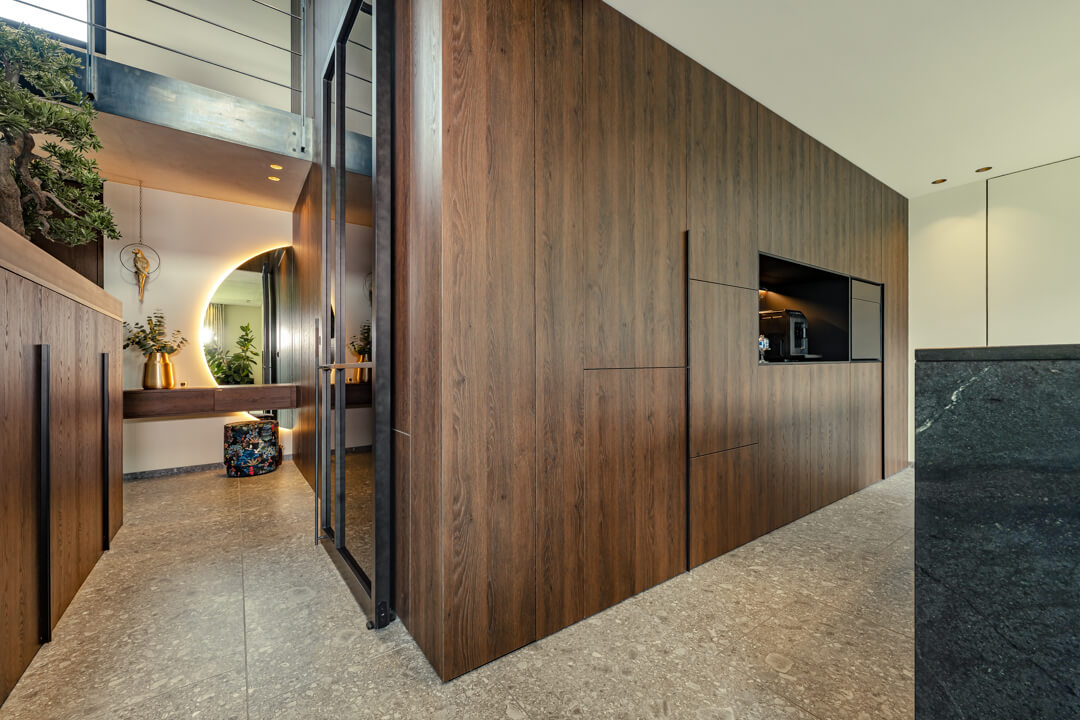 A modern kitchen cabinet wall in dark oak.