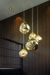 Roasted oak wall panelling with clustered glass pendant lamp