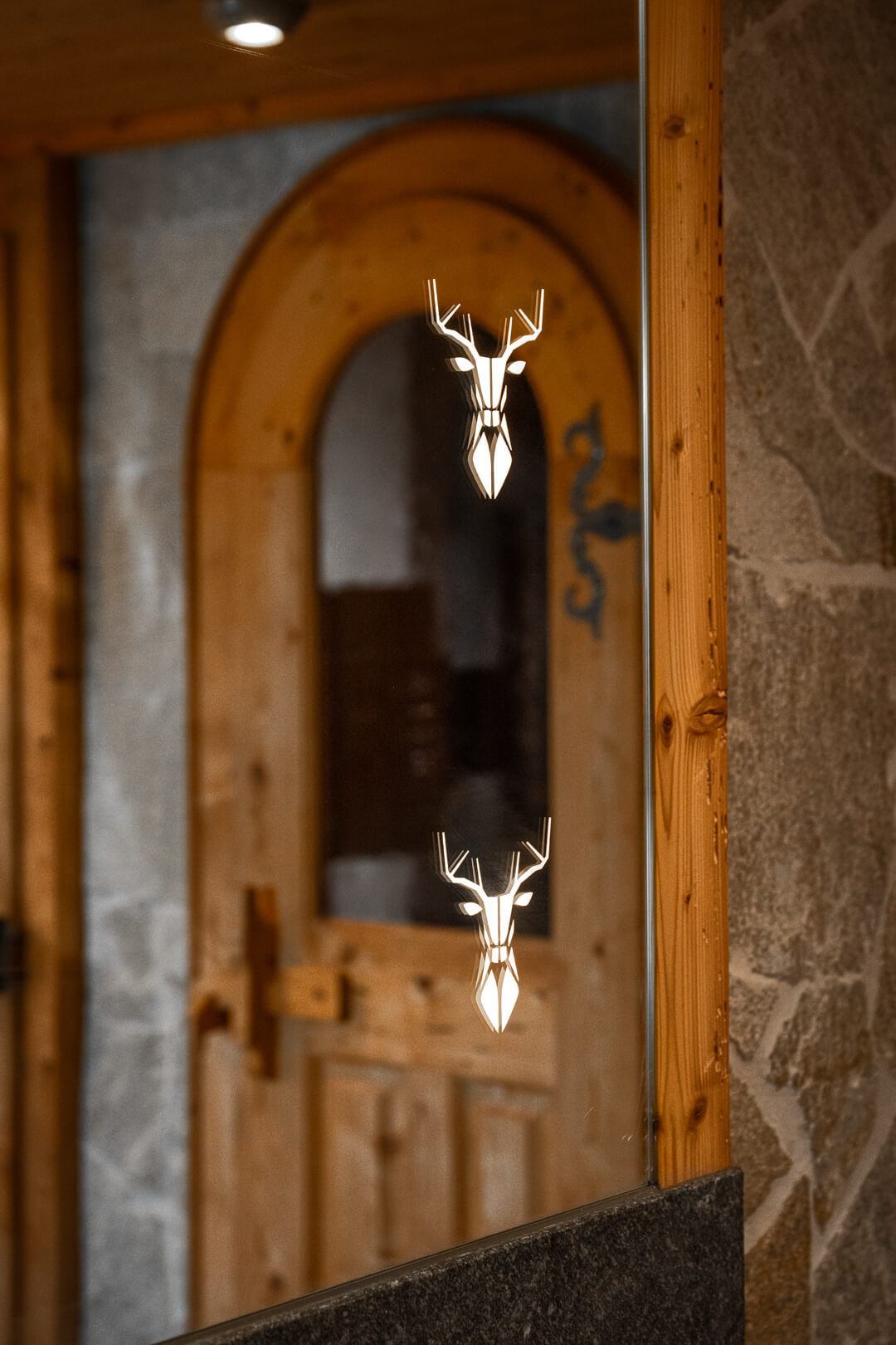 Chalet bathroom mirror featuring LED-lit stag designs.