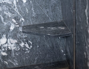 Shower with built-in stone bench in chalet bathroom.