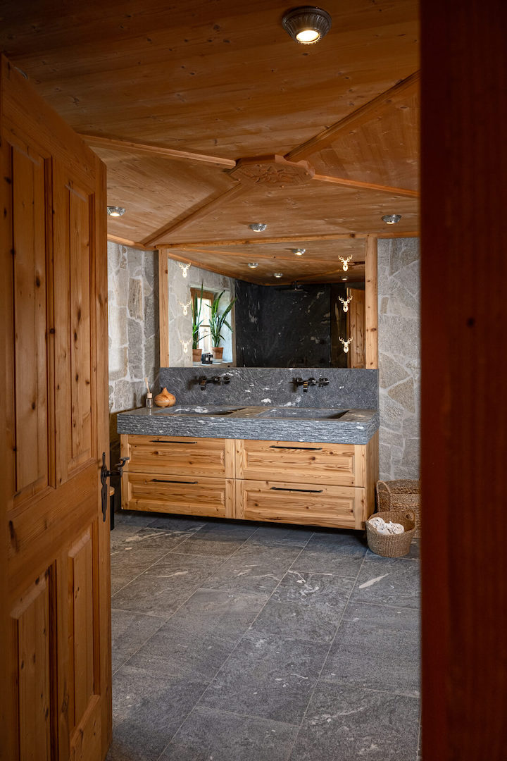 Luxury chalet bathroom featuring oak furniture and Rauriser natural stone.