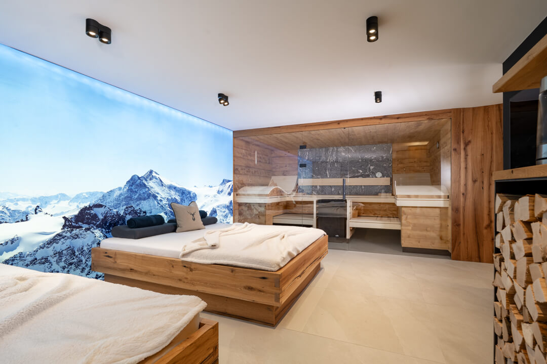 Wellness relax bed made of oak with winter mountain photo canvas backdrop. Sauna with wood and Stone.