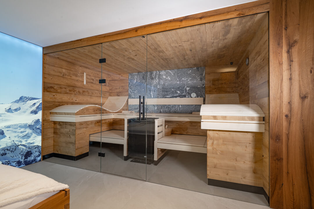 Reclaimed spruce wood sauna with rough gray natural stone in a chalet.