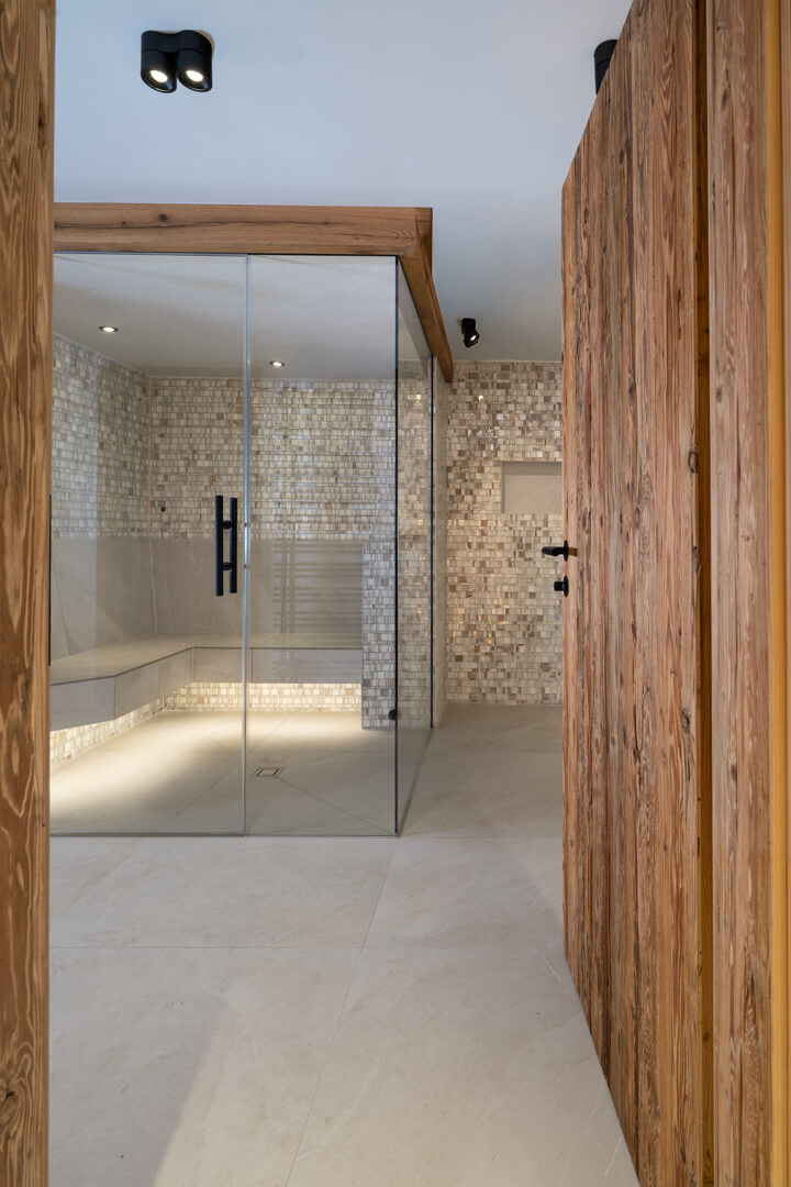 Steam bath with glass and oak façades and mother-of-pearl tiles.