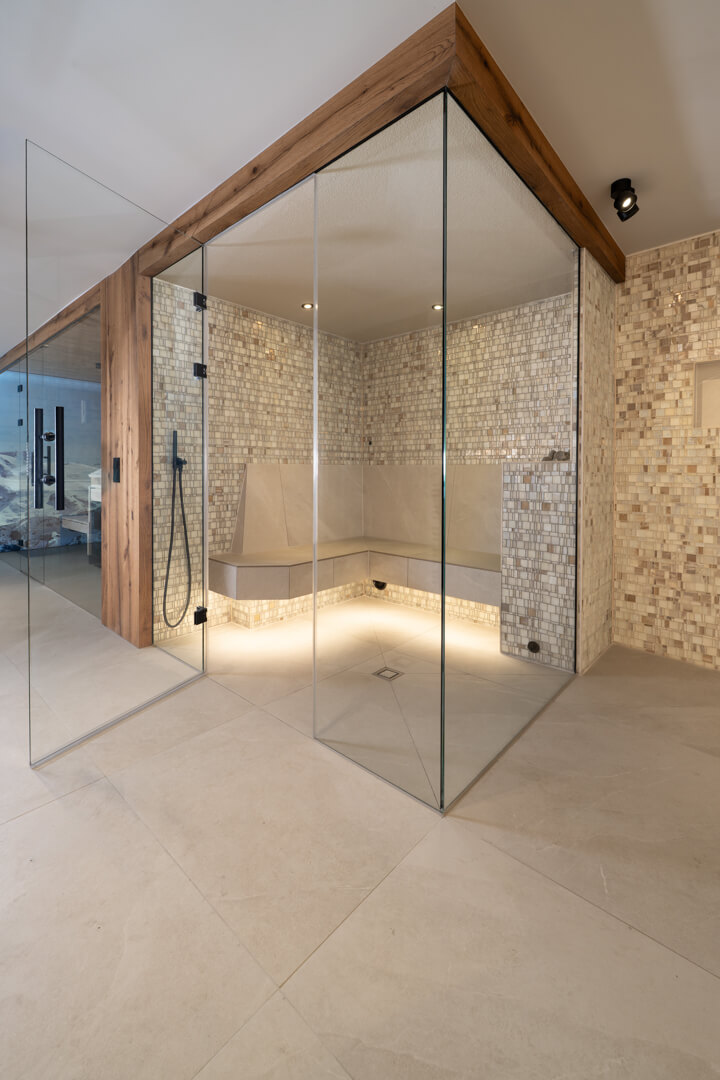 Steam bath with glass and oak façades and mother-of-pearl tiles.