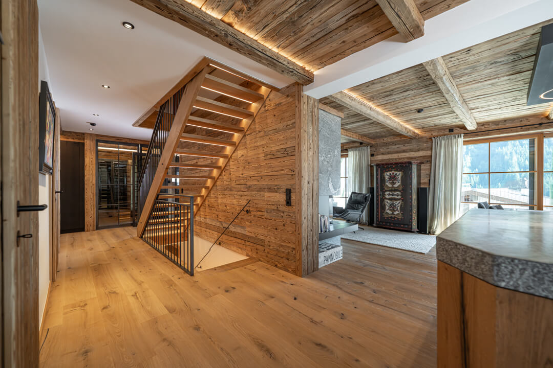Alpine Chalet Interior with Reclaimed Wood Walls and Lit Oak Staircase