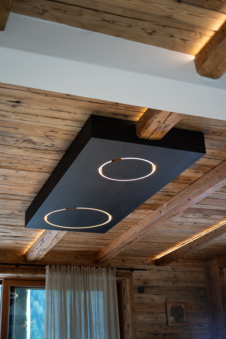 Black Occhio lamp panel for modern chalet interior lighting.