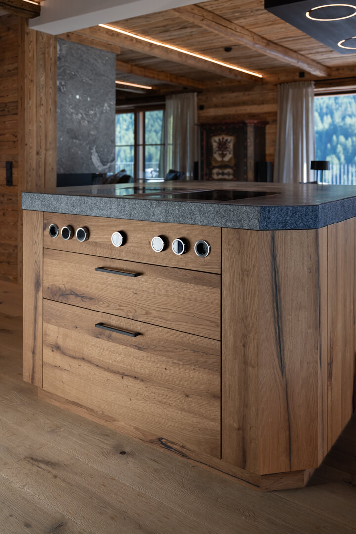 Chalet kitchen with solid oak island, Rauriser natural stone countertop, and modern Bora cooktop.