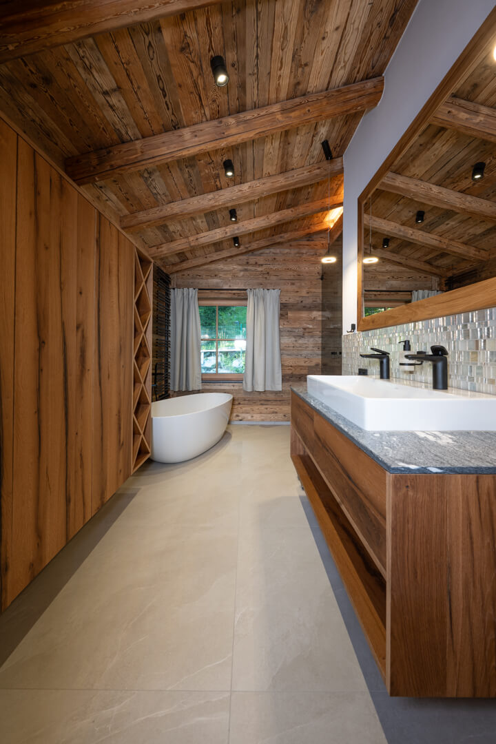 Luxury chalet bathroom with mother-of-pearl and reclaimed wood façades, oak furniture, and light tiles.