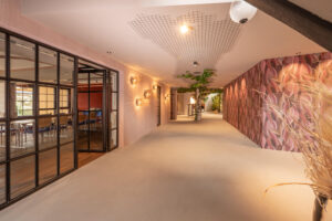 Hotel gallery with loft-style doors and pink floral wallpaper.