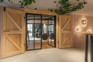 Hotel gallery with loft-style doors and oak barn doors leading to the fireplace lounge.