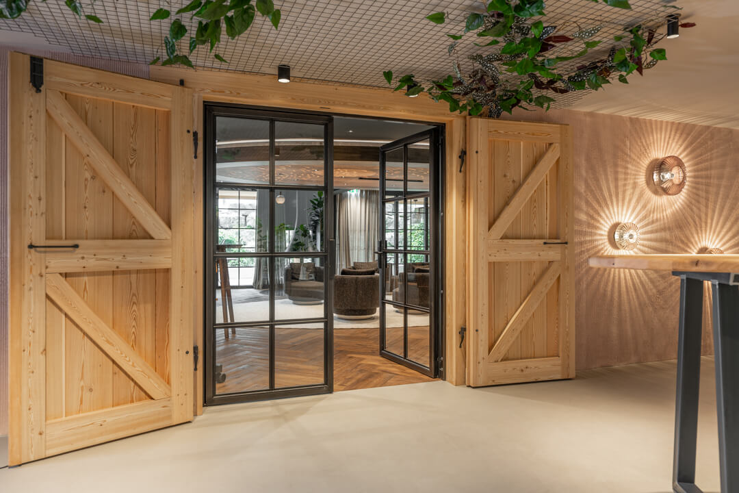 Hotel gallery with loft-style doors and oak barn doors leading to the fireplace lounge.
