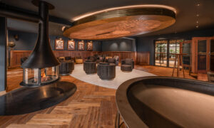 Fireplace room with dark interior, wood paneling, and herringbone floor at Hotel Rössle.