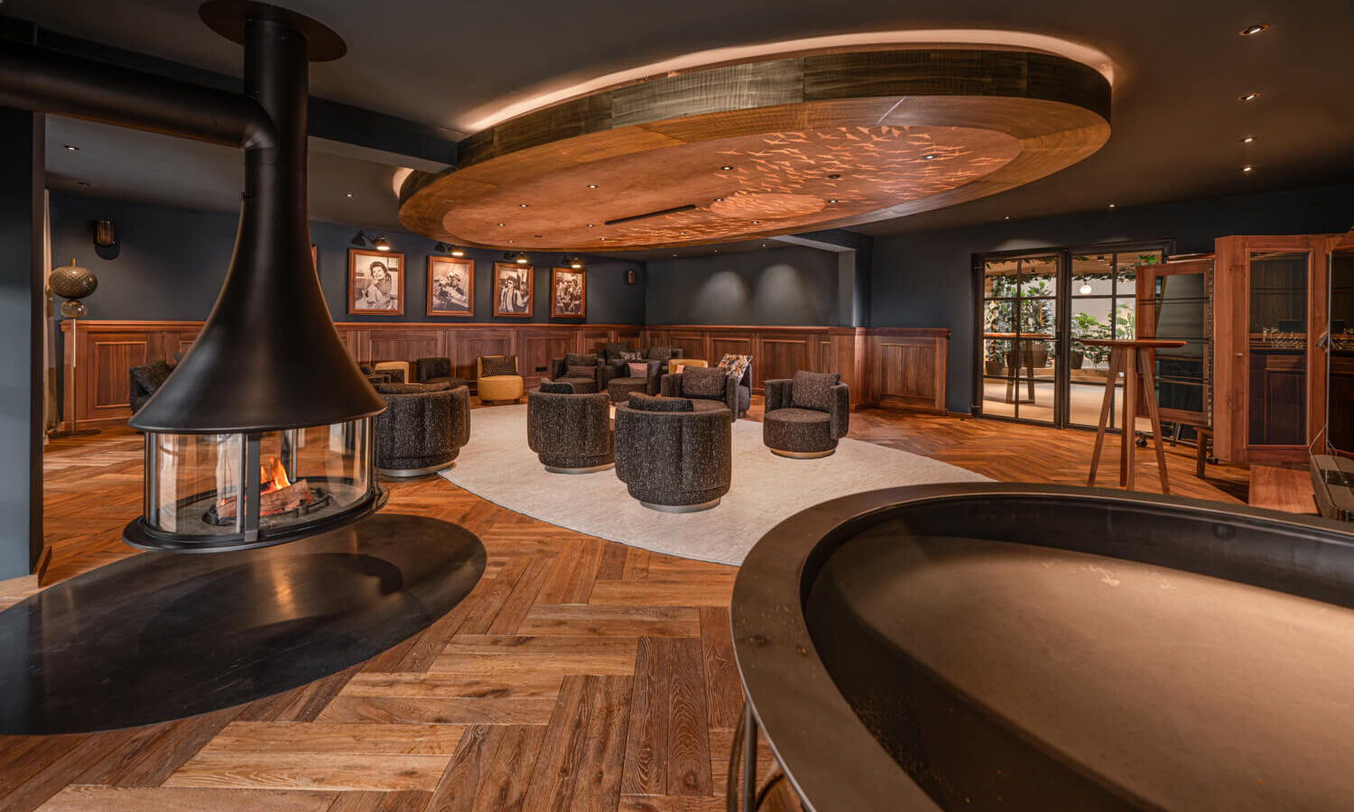 Fireplace room with dark interior, wood paneling, and herringbone floor at Hotel Rössle.