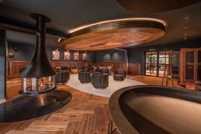 Fireplace room with dark interior, wood paneling, and herringbone floor at Hotel Rössle.