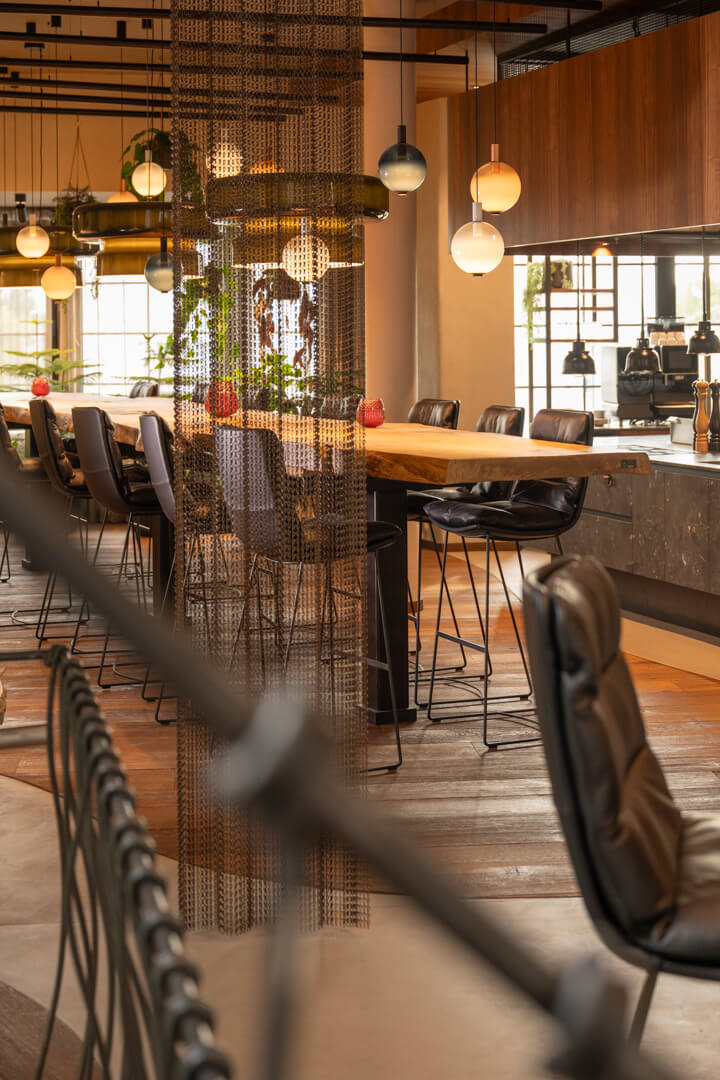 7.5-meter oak table with dynamic natural edge. Metal stair railing.