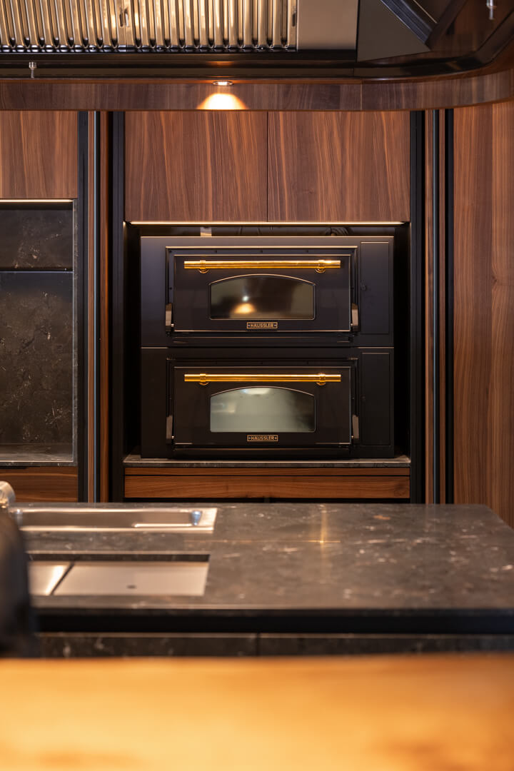 Black pizza oven in walnut kitchen