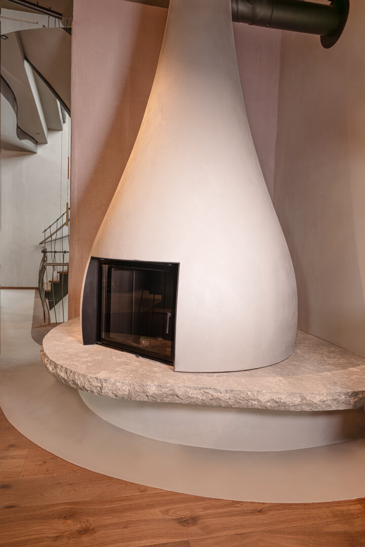 White sculpted Teardrop Fireplace with stone bench
