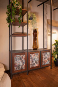 Wooden cabinet with steel frame, stone shelves, and textured colored fronts.