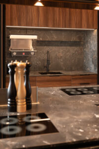 Kitchen with grey stone countertop and walnut wood fronts
