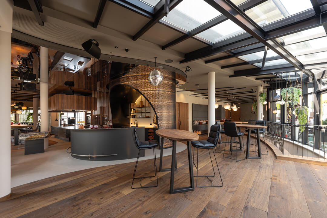 Hotel foyer with walnut bar tables, dark wooden floor, and luxury design bar. Walnut kitchen and oak table.