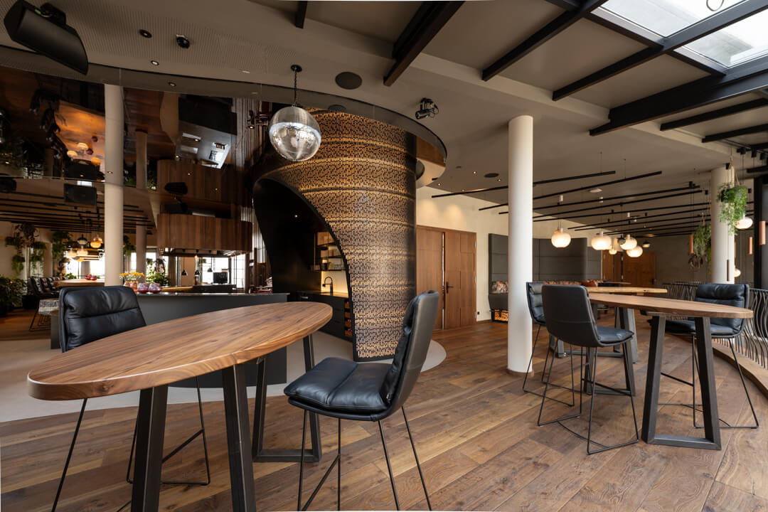 Hotel foyer with walnut bar tables, dark wooden floor, and luxury design bar.
