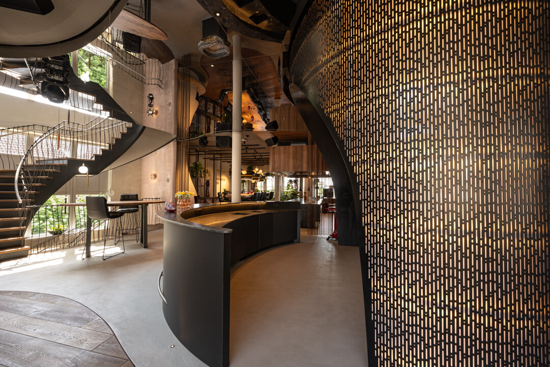 Hotel bar with natural stone countertop and impressive backlit delicate steel structure.