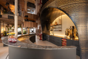 Hotel bar with natural stone countertop and impressive backlit delicate steel structure.