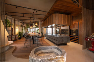 Luxury walnut kitchen with grey natural stone island. 7,5 long Oak table.