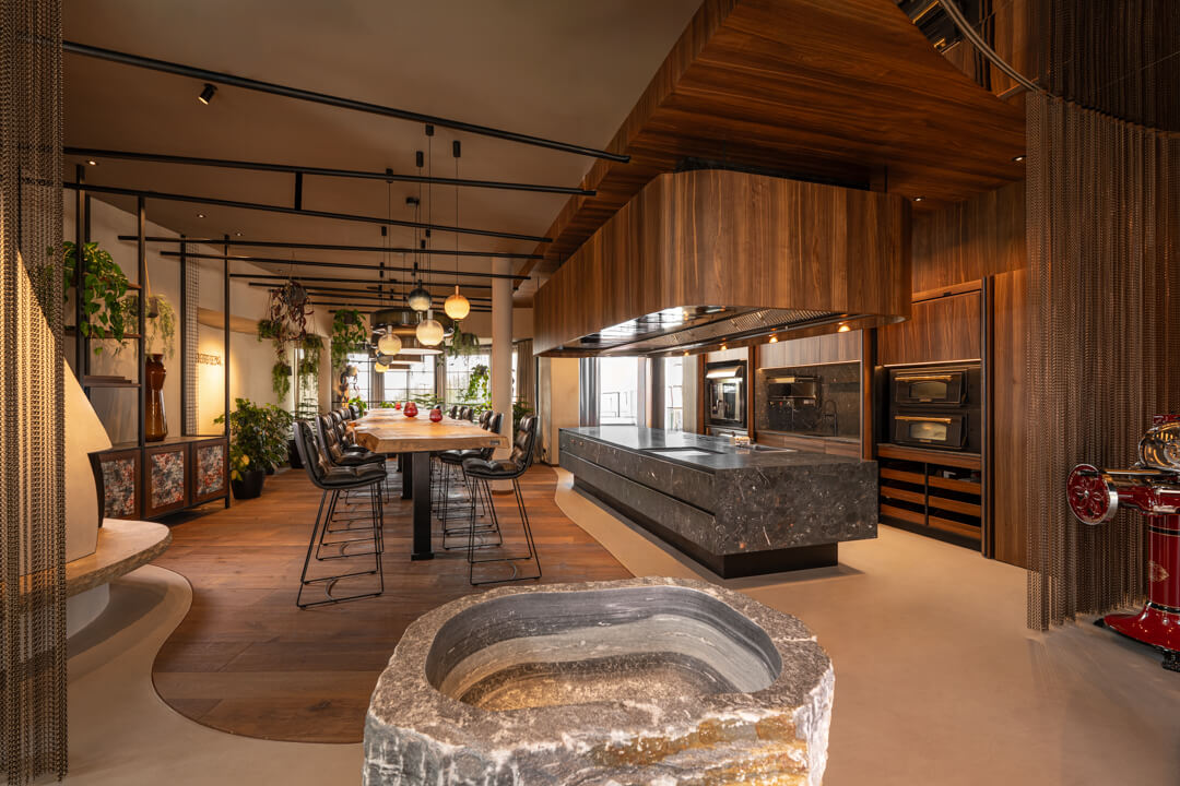 Luxury walnut kitchen with grey natural stone island. 7,5 long Oak table.