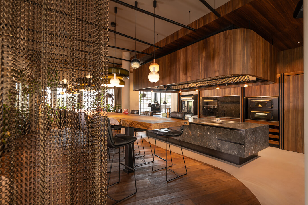Luxury walnut kitchen with grey natural stone island. 7,5 long Oak table. Bronze metal curtain.