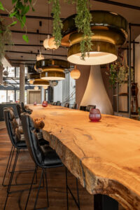 Long oak table natural dynamic edge. Black leather bar chairs