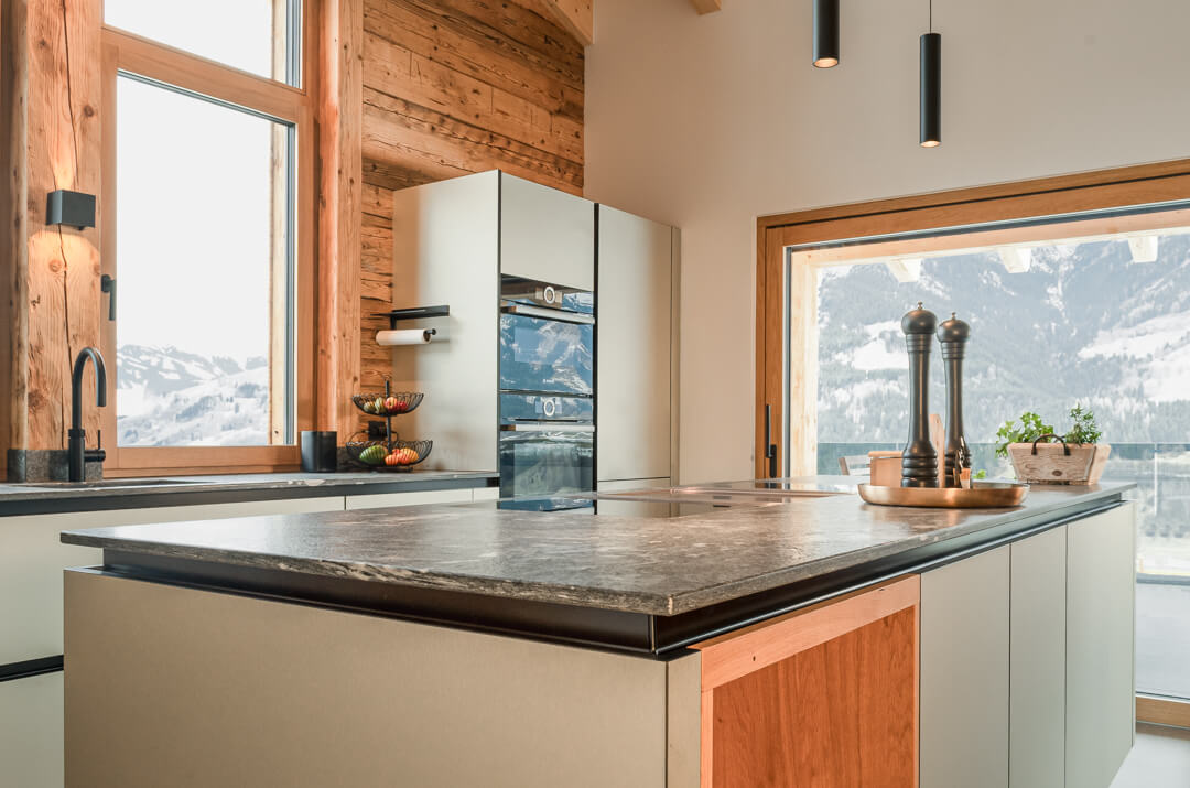Chalet kitchen with island light green with wooden details and stone countertop